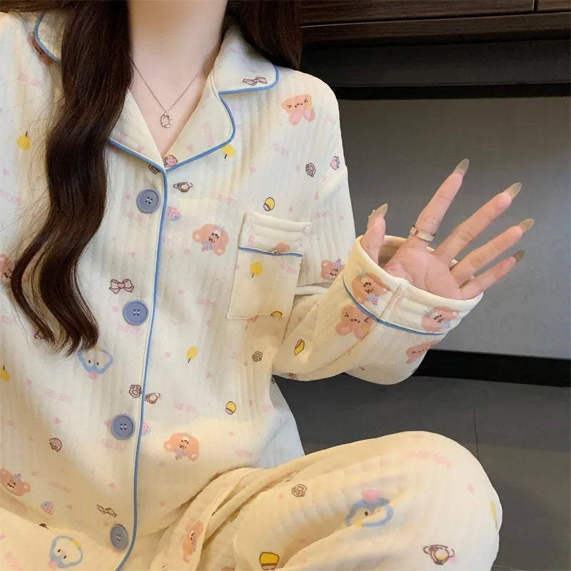 Person wearing a white pajama set with cartoon designs, sitting on a dark surface.