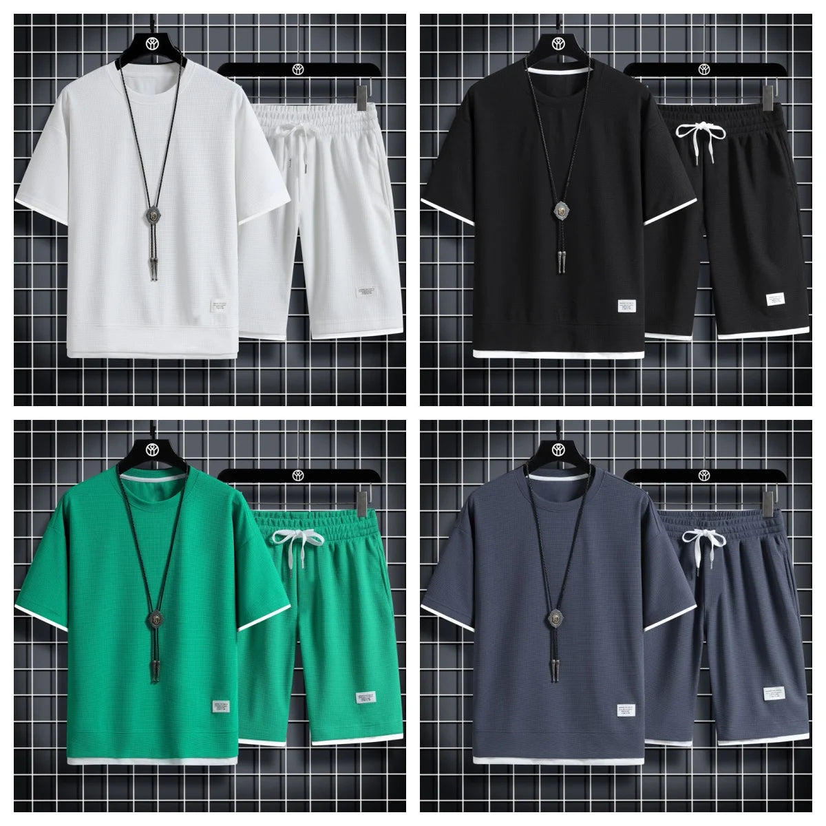 Four sets of clothing in white, black, green, and gray with matching shorts on hangers against a grid-patterned background.