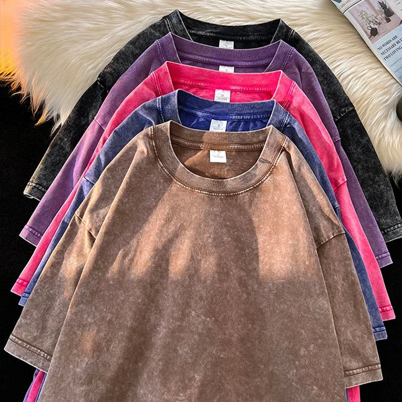Stack of colorful t-shirts on a textured surface