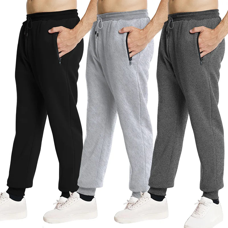 Three pairs of jogger pants in black, gray, and another gray shade on a white background.