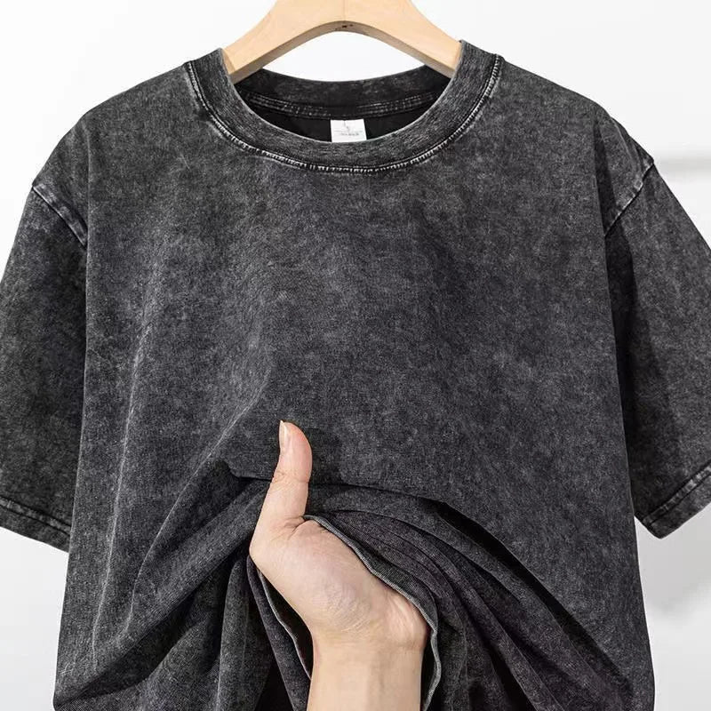 Black t-shirt on a hanger with a hand touching the fabric