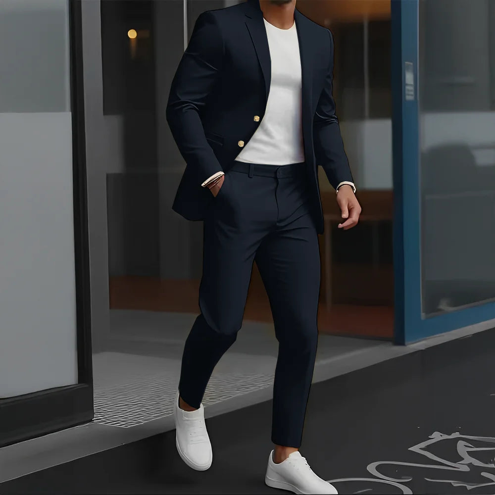 Person wearing a navy suit with white shirt and shoes, standing outside a building.