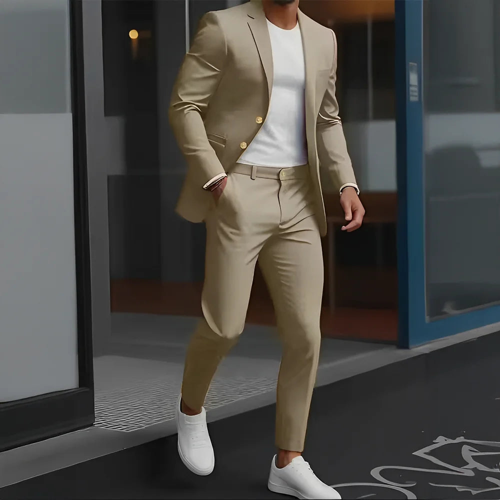 Person wearing a beige suit and white shoes standing in front of a glass door.